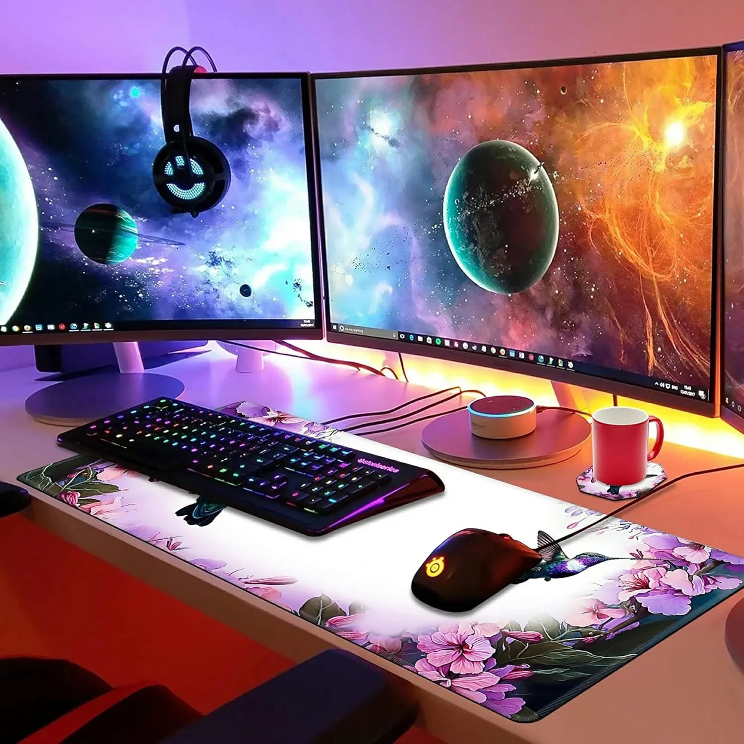 RGB backlit keyboard and gaming mouse on floral desk mat with triple curved space-themed monitors and hanging LED headset