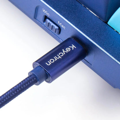 Blue mechanical keyboard USB-C cable by Keychron, Win/Mac switch visible, modern gaming gear