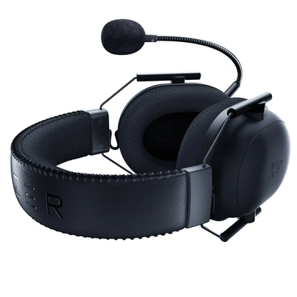 Black gaming headset with padded earcups and attached flexible microphone on white background