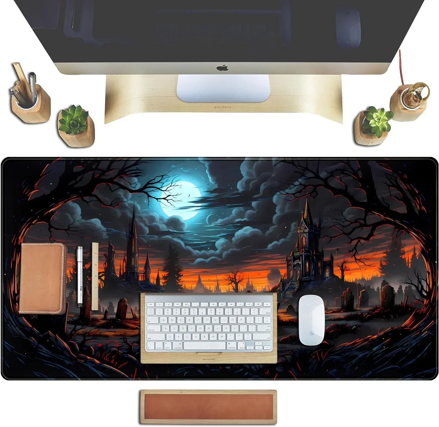 Gaming desk setup with spooky castle and full moon RGB desk mat, Apple keyboard and mouse, wooden accessories