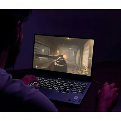 Gamer playing a first-person shooter on a backlit gaming laptop in a dark room