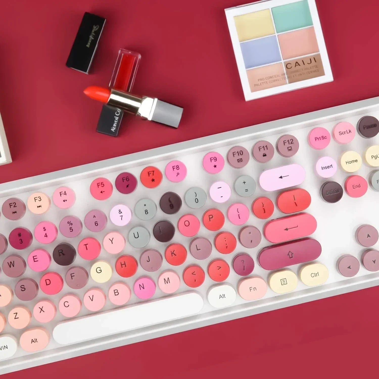 Retro 8-bit style pastel keyboard with round keycaps, lipstick, and makeup on red background