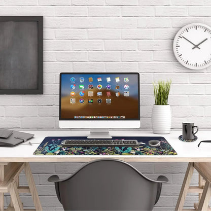 Modern white computer desk setup with all-in-one monitor, floral desk mat, wireless keyboard and mouse, plant, and wall clock