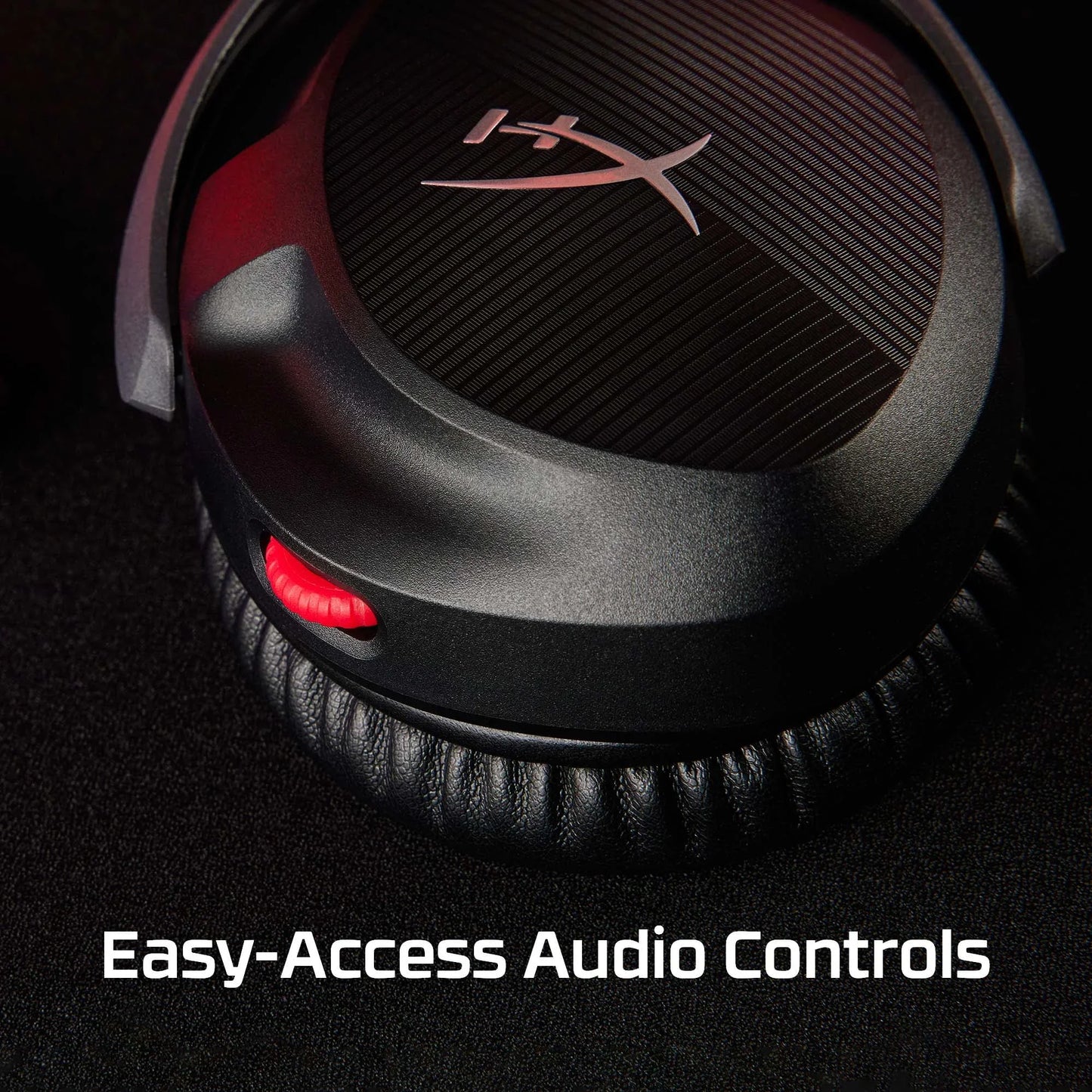 Close-up of HyperX headphones earcup with red audio control wheel on black background
