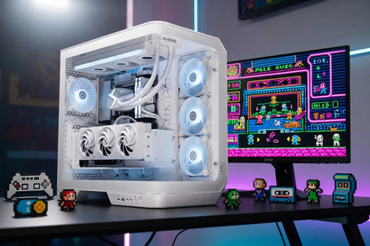 White gaming PC with RGB fans on a desk, retro 8-bit figures, and pixel art game on monitor