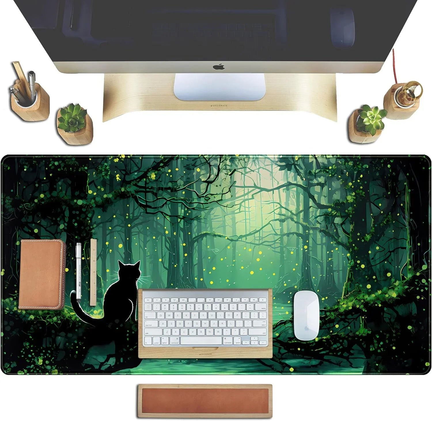 Gaming desk setup with large forest-themed mouse pad featuring glowing fireflies and black cat silhouette, keyboard, mouse, and wooden accessories