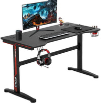 Black and red gaming desk with monitor, keyboard, mouse, headset, cup holder, speaker, and gaming figurine