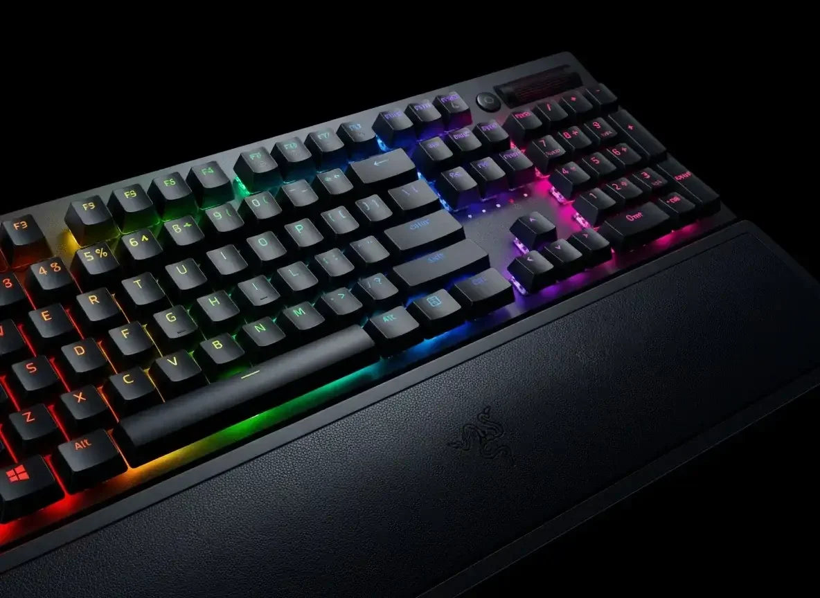 Mechanical RGB backlit gaming keyboard with tactile keys and wrist rest on black background