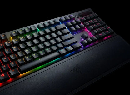 Mechanical RGB backlit gaming keyboard with tactile keys and wrist rest on black background