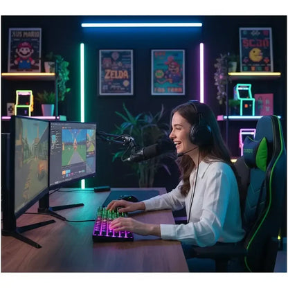 Female gamer streaming at RGB-lit setup with dual monitors, headset, and gaming chair
