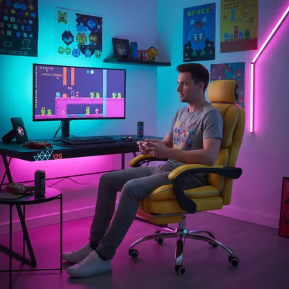 Man gaming at desk with LED lights, colorful posters, and retro video game decor