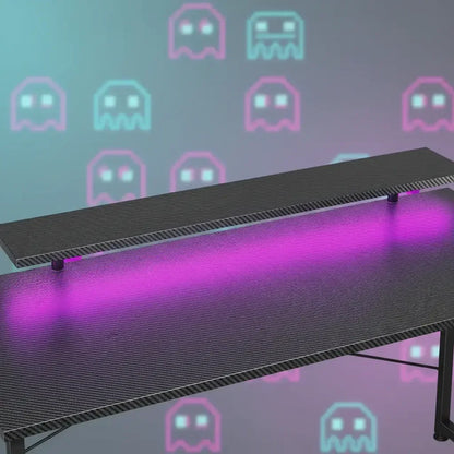 Modern gaming desk with pink LED light and Pac-Man ghost background