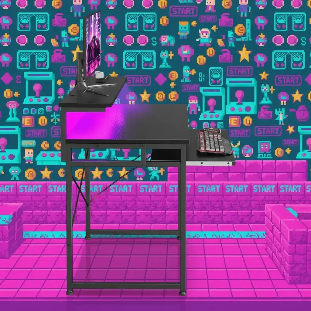 Black gaming desk with monitor, keyboard, and mouse against a colorful pixel art video game themed wall