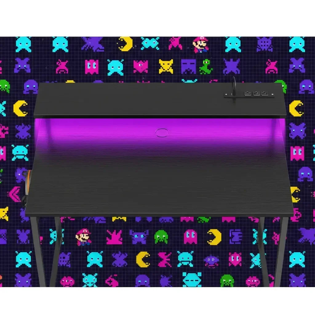 Black modern gaming desk with purple LED lighting against a colorful retro video game character background