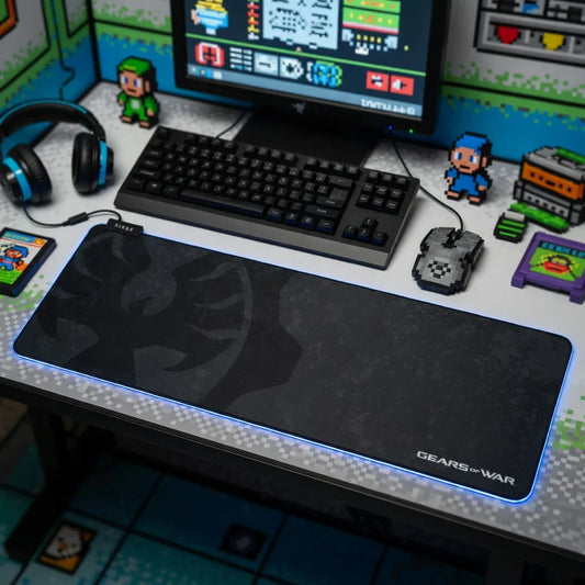 Retro gaming desk setup with RGB Gears of War mouse pad, pixel art mouse, keyboard, and headset.