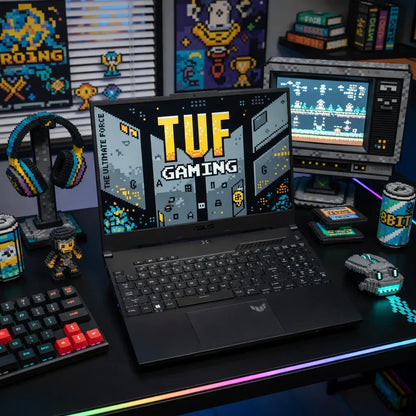 Retro gaming desk setup with ASUS TUF laptop, pixel art keyboard, headset, and accessories