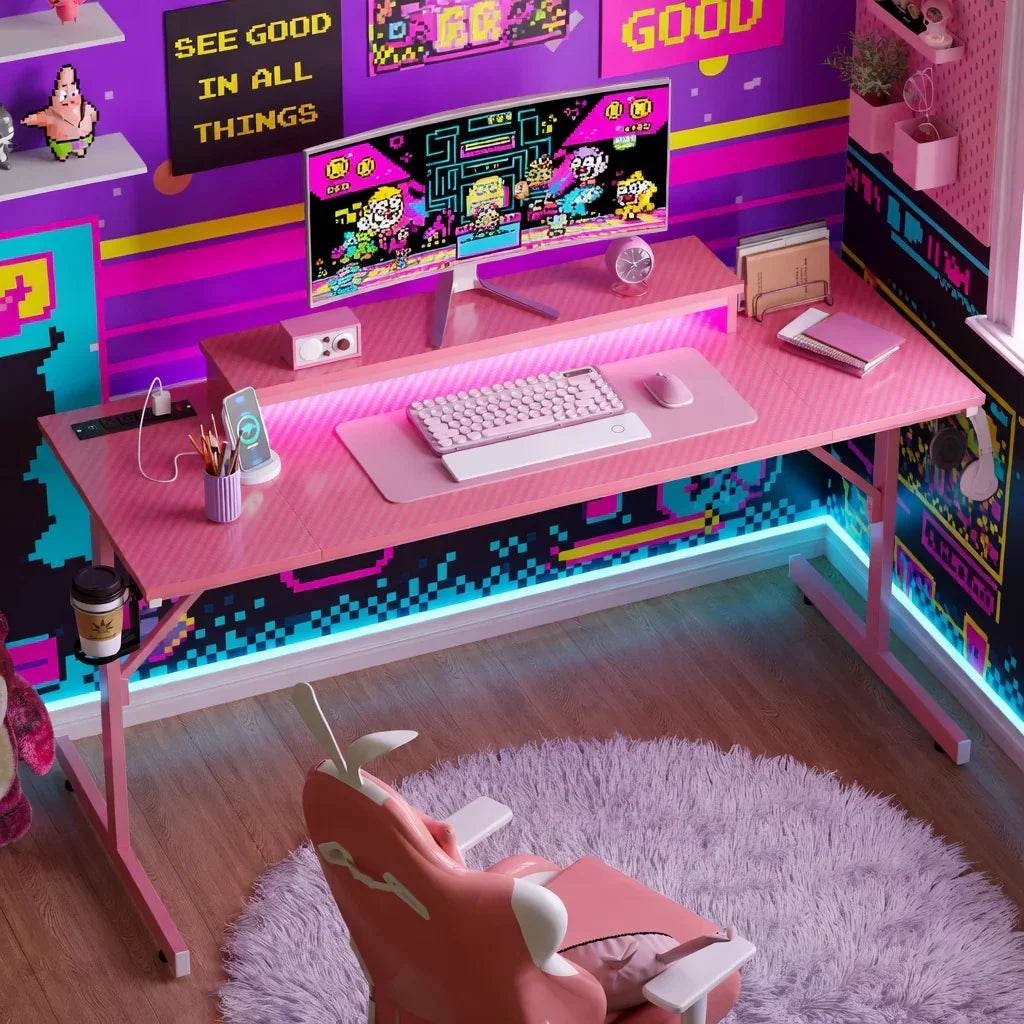 Retro 8-bit gaming setup with pink desk, RGB lights, dual monitors, and gaming chair
